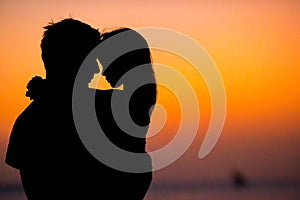 Little girl and dad silhouette in the sunset at the beach