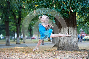 Little girl dancer jump in summer park