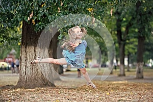 Little girl dancer jump in summer park