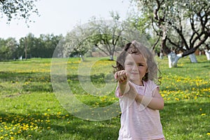 Little girl on dandelion lawn background