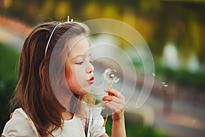 Little girl with dandelion in park