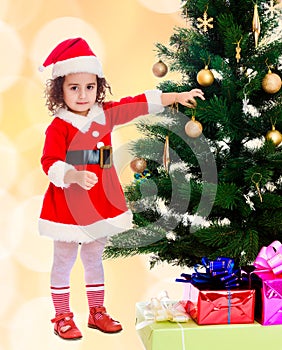 Little girl decorates the Christmas tree