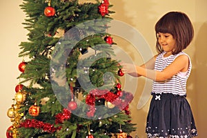 Little girl decorates Christmas tree