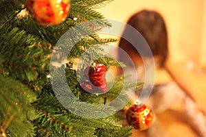 Little girl decorates Christmas tree