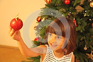 Little girl decorates Christmas tree