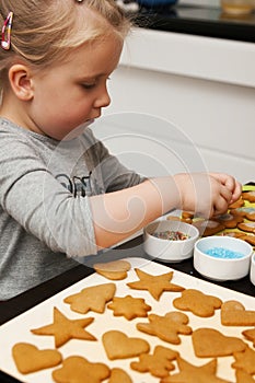 Little girl decorating Christmas cookies