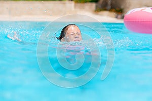 Little girl deftly swim underwater in pool