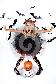 Little Girl with a demon devil costume dressed up in black red dress and red devil horns for pumpkin patch and halloween party