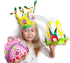 Little girl demonstrating her craft works, Easter bonnets