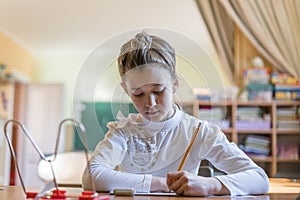 little girl at the desk is writing