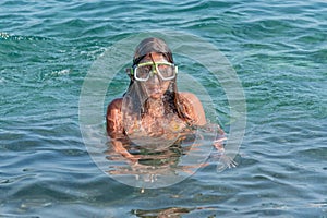 Little girl with diving mask play in the sea and having a great time