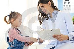 Little girl at the doctor for a checkup. Child auscultate the heartbeat of the doctor