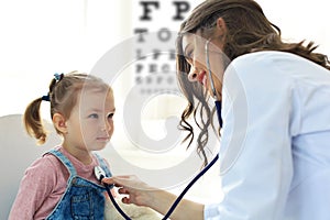 Little girl at the doctor for a checkup. Doctor woman auscultate the heartbeat of the child