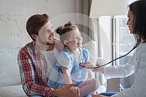 Little girl at the doctor for a checkup. Doctor woman auscultate the heartbeat of the child. photo