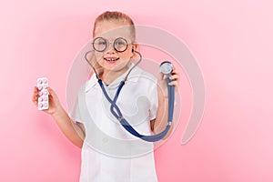 Little girl in doctor costume with pills