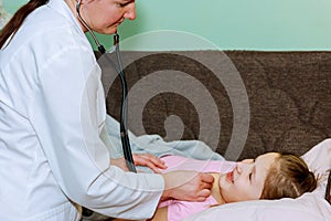 Little girl at the doctor - health professional checking her with stethoscope