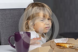 The little girl doesn`t want to eat pizza. Concept: children`s whims at the table, not the desire to eat