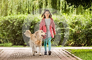 Little girl with dog going along alley