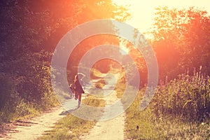 A little girl with a dog runs along a country road