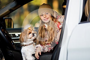 Little girl with a dog travels by car