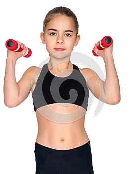 Little girl doing exercises with dumbbells.