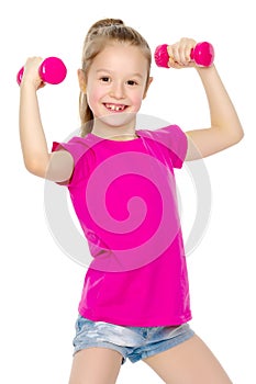 Little girl doing exercises with dumbbells.