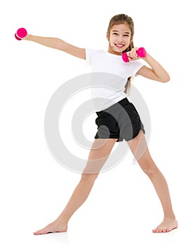 Little girl doing exercises with dumbbells.