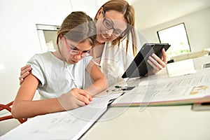Little girl doing homework with her mother