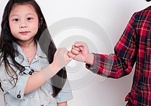 Little girl doing Pinky Swear with her sister