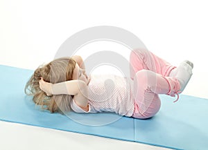 Little girl doing sport exercises