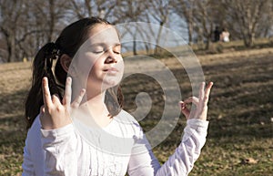 Little girl doing yoga meditating