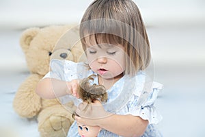 Little girl with doll combing hair playing