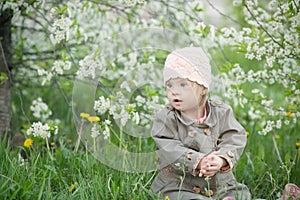 Little girl with Down syndrome in the mouth pulls dandelions