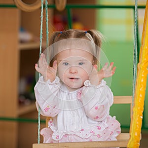 Little girl with Down syndrome playing hide and seek