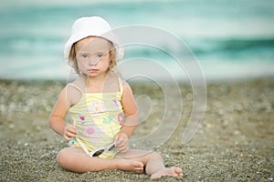 Little girl with Down syndrome playing sunglasses on the beach