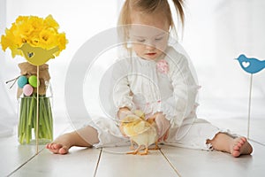 Little girl with Down syndrome playing with yellow chickens