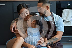 Little girl dozed off in the arms of her parents