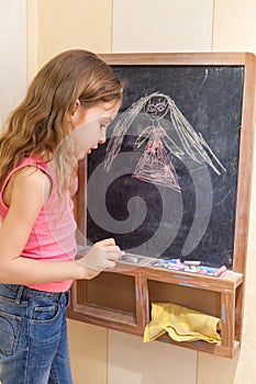 Little girl draw on blackboard photo