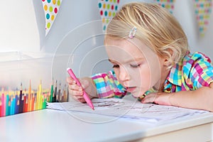 Little girl drawing with colorful pencils