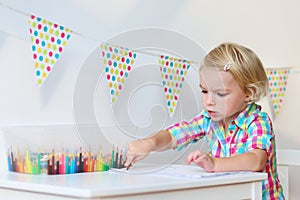 Little girl drawing with colorful pencils