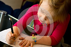 Little girl drawing with pen