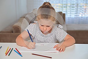 Little girl drawing with pencils at home