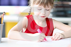 Little girl drawing with pink felttip pen photo