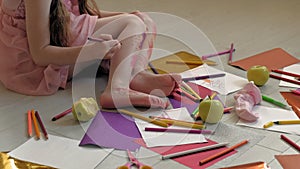 Little girl draws on her feet with felt-tip pens, children`s creativity, development