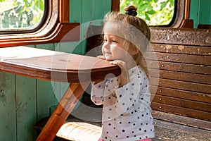 Little girl dreaming sitting in old style retro train