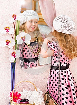 Little girl in dress looking in mirror