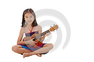 Little girl in dress playing the ukulele