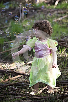 Little girl dressed as a fairy with soap bubbles