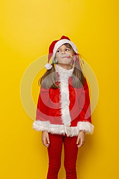 Little girl dressed as Santa blowing party whistle