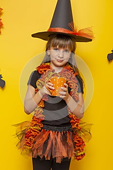 Little girl dressed as a witch drinking tea for Halloween